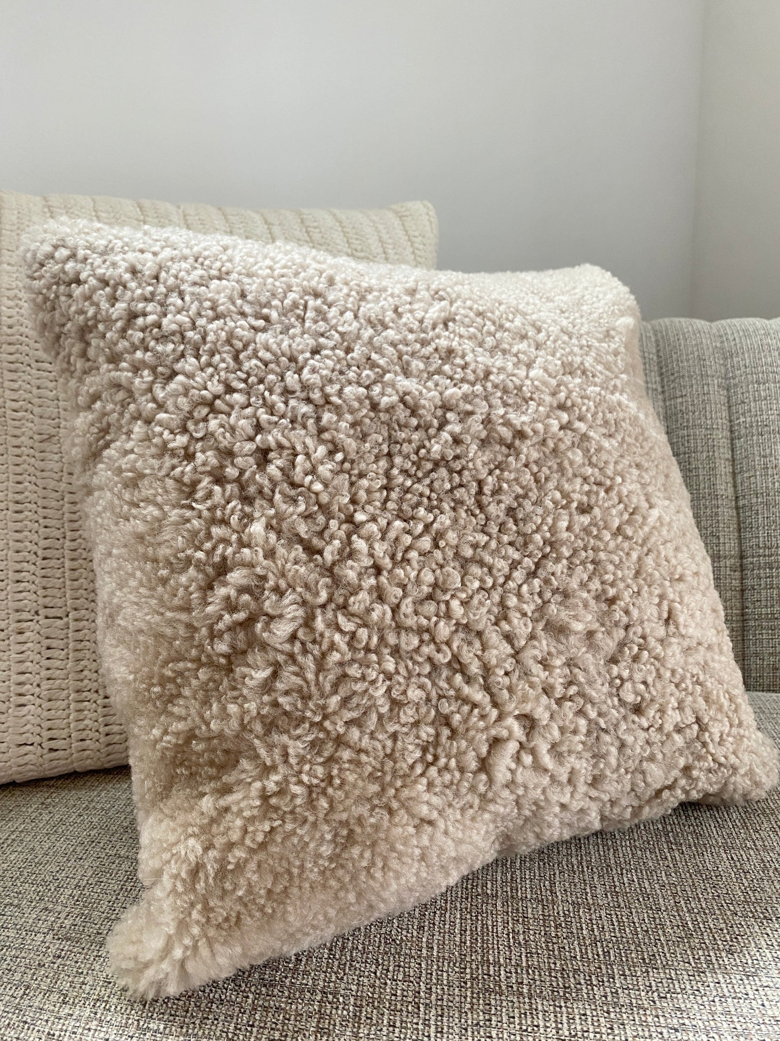 Side view of tan shearling sheepskin pillow