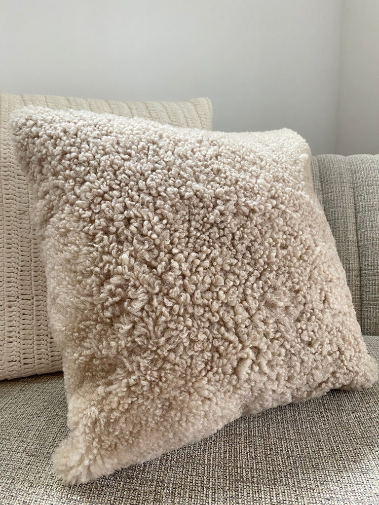 Side view of tan shearling sheepskin pillow