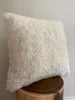 ivory shearling sheepskin pillow on a wooden block 