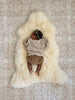 Baby lying on a bright ivory nursery sheepskin