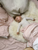 Child sleeping on a bright ivory nursery sheepskin