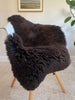 Dark Brown sheepskin rug draped over a chair 