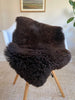 Dark Brown sheepskin rug draped over a chair 