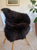 Dark Brown sheepskin rug draped over a chair 