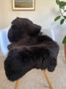 Dark Brown sheepskin rug draped over a chair 