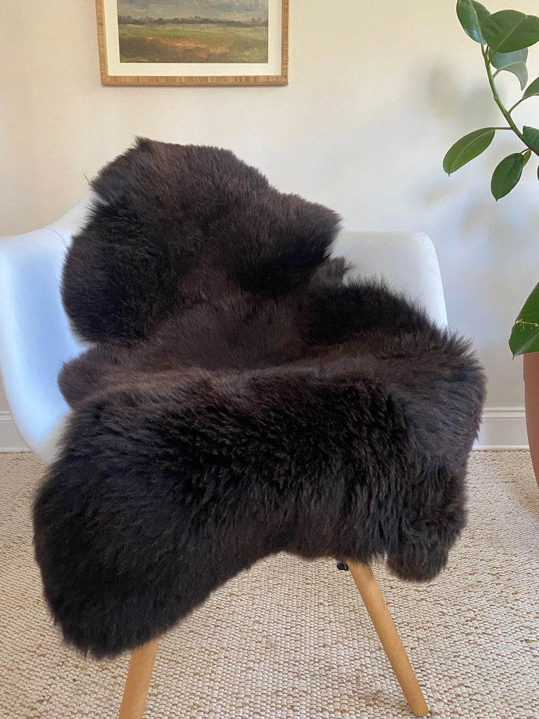 Dark Brown sheepskin rug draped over a chair 