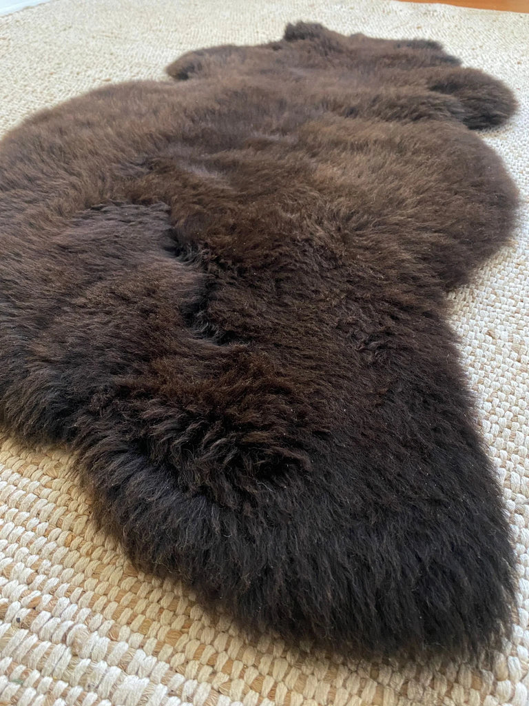 Dark Brown fur rug on a textured surface