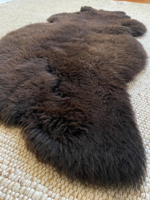 Dark Brown fur rug on a textured surface