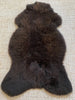 Top view dark brown fur rug on a textured surface