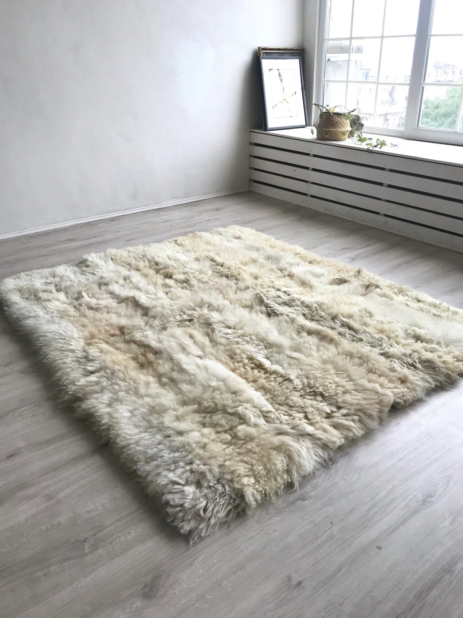 Creamy ivory sheepskin bed cover rug on a wooden floor 