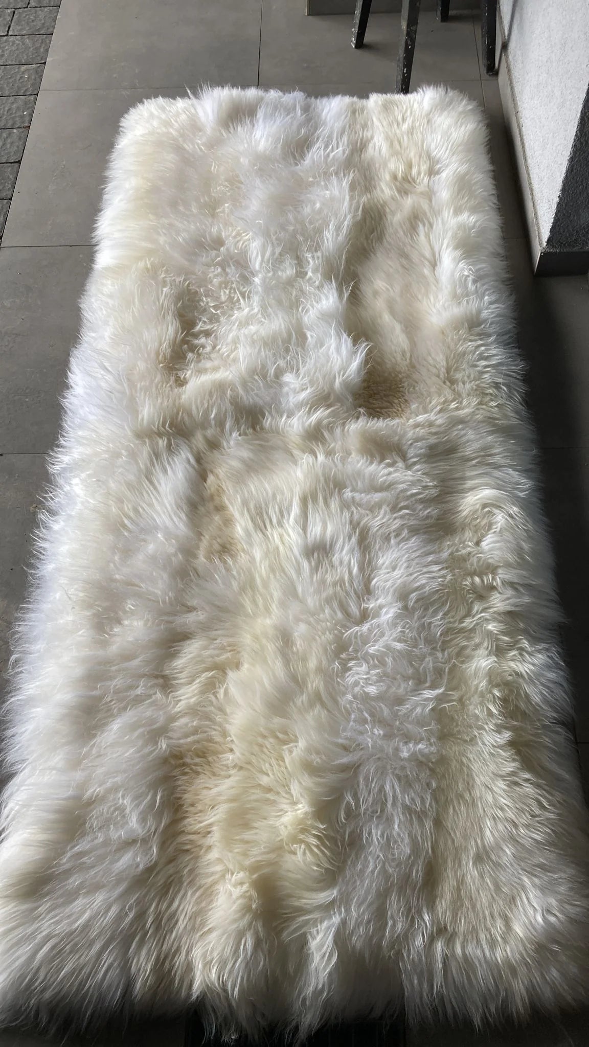 Top-view of creamy ivory sheepskin bed cover rug