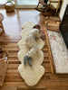 Child lying on a double shorn ivory sheepskin