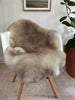 Greyish brown shortfur sheepskin over a chair 