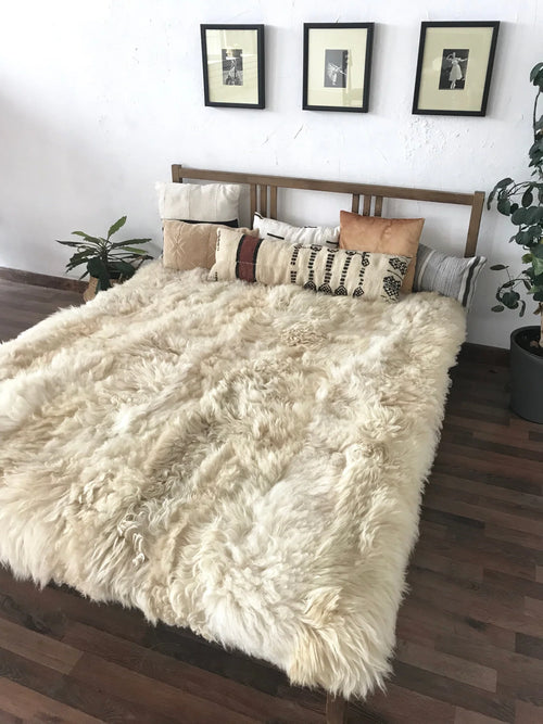 Bed with ivory plush sheepskin blanket