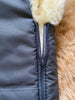 Close-up of a gray jacket with a zipper and beige interior lining.