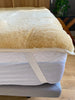 Edge-view of medical sheepskin crib topper