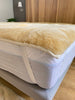 medical sheepskin crib topper on a bed 