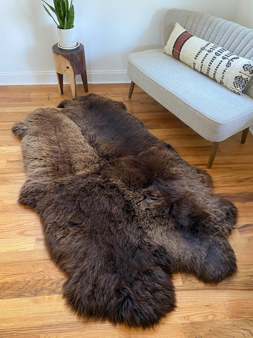 Plush rich brown sheepskin quad on a wooden floor 