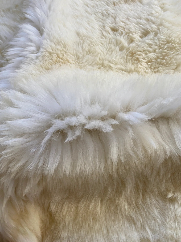 Corner view of rug highlighting fluffy edges and creamy tones