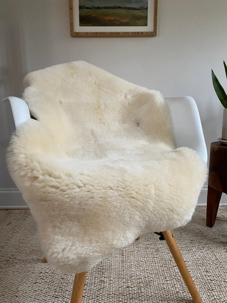 Ivory sheepskin rug displayed on a chair in natural light