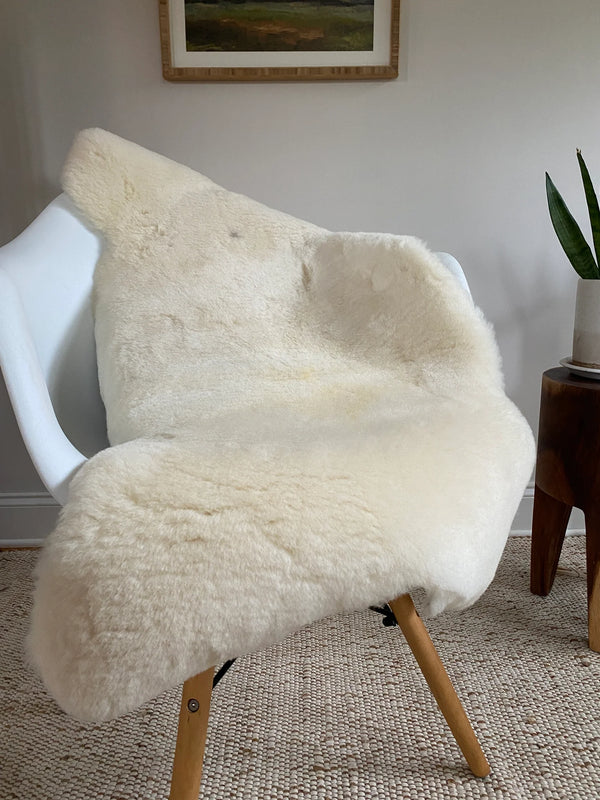 Ivory sheepskin rug displayed on a chair in natural light