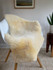 Ivory sheepskin rug displayed on a chair in natural light