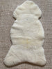 Top-down photo showing overall shape and size of ivory sheepskin rug