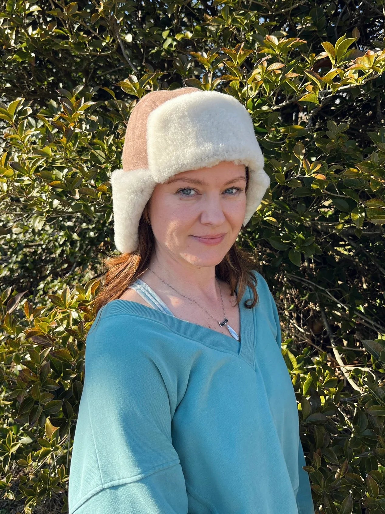 Woman wearing a sheepskin and leather pilot hat in tan 