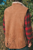 Person wearing a brown sheepskin mens vest over a red plaid shirt in an outdoor setting.