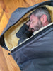 Man lying inside a sheepskin sleeping bag