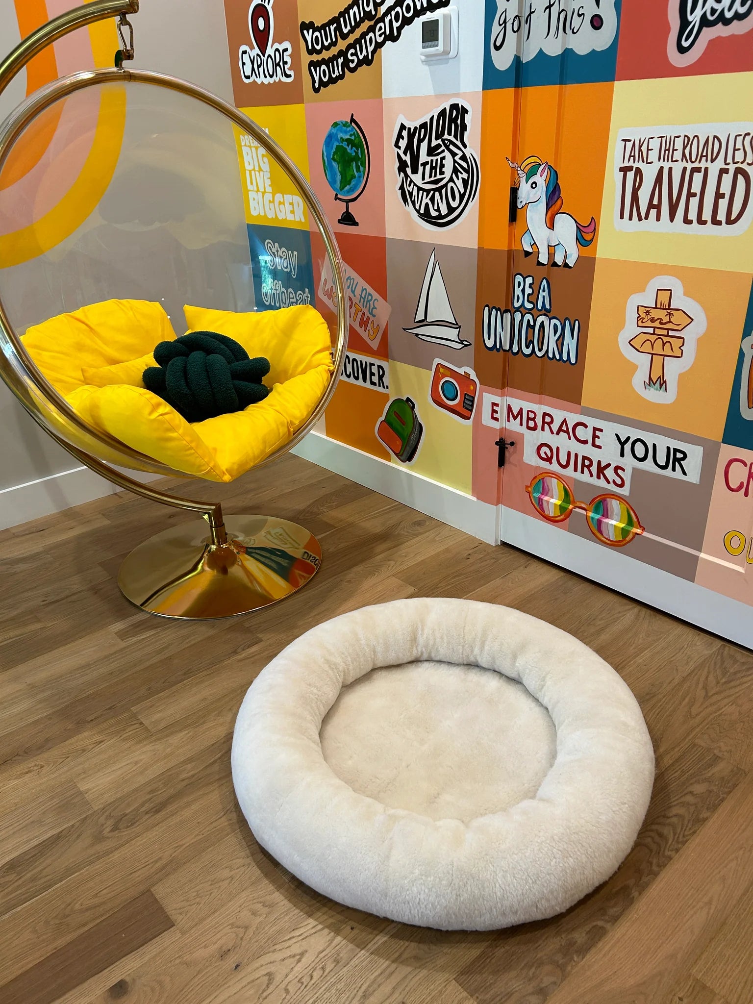 Snugly short fur sheepskin dog bed on a wooden floor 