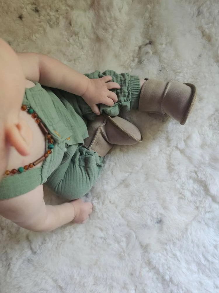 Baby wearing terra slipper sheepskin minimalist footwear for kids with tan fur