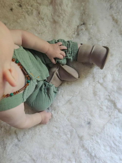 Baby wearing terra slipper sheepskin minimalist footwear for kids with tan fur