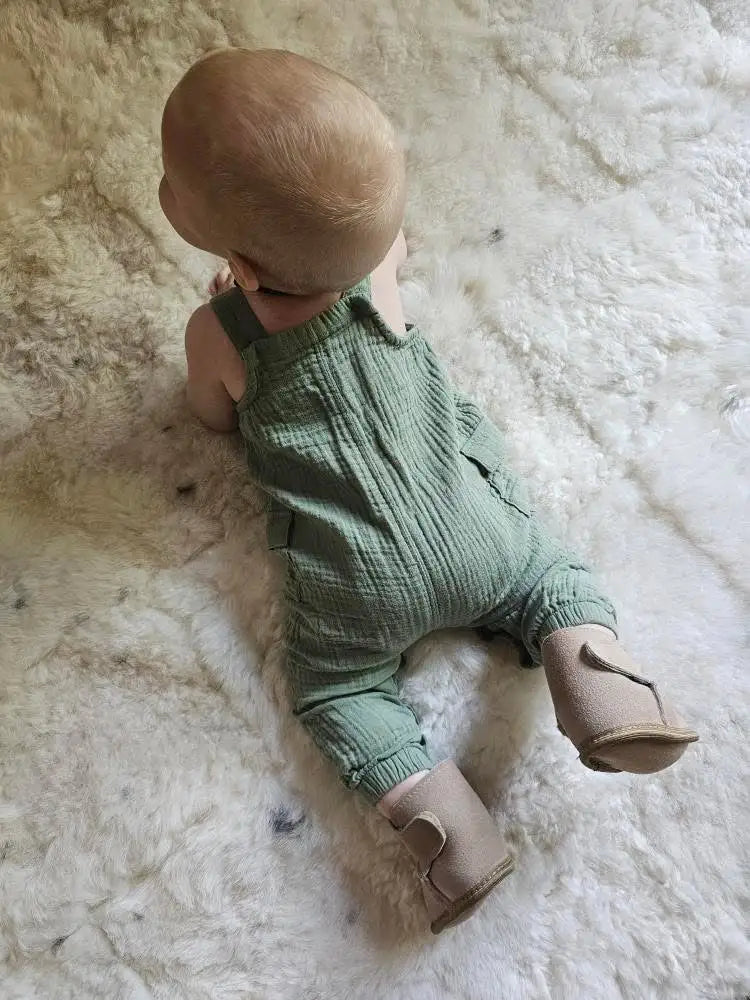 Baby wearing terra slipper sheepskin minimalist footwear for kids with tan fur