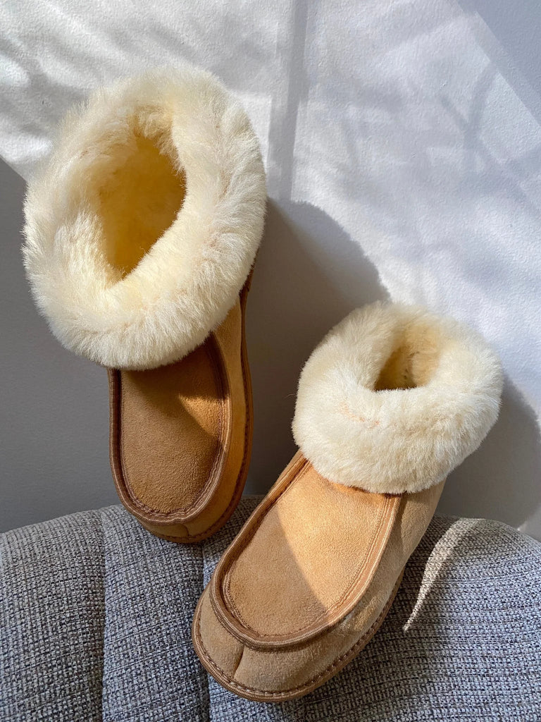 Pair of the classic slipper 100% sheepskin in tan on a textured surface