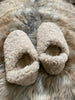 Pair of beige slippers on a fur surface