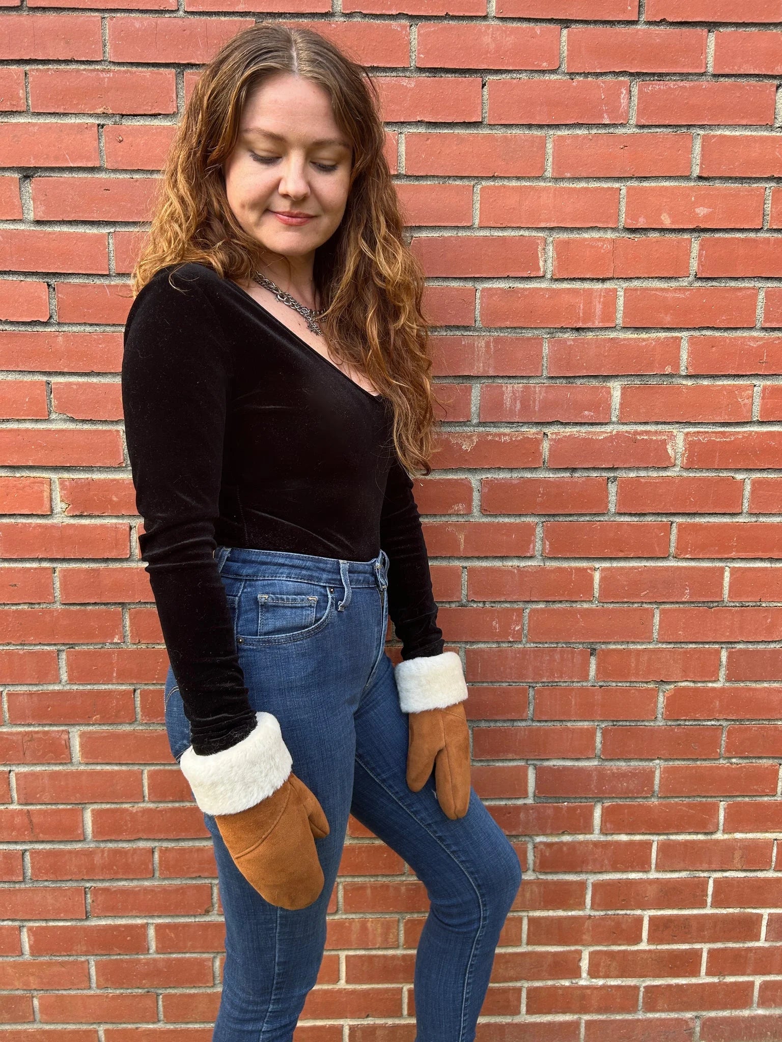 Woman wearing the haven sheepskin mitten in amber