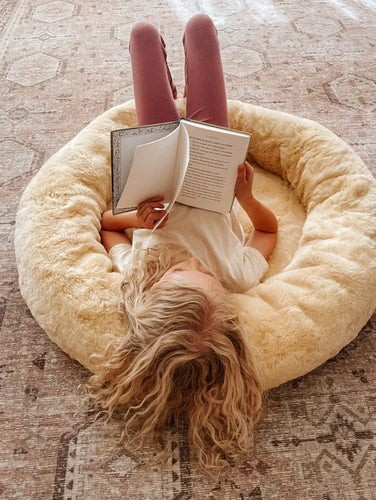 Person lying on the snugly reading a book