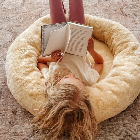 Person lying on the snugly reading a book