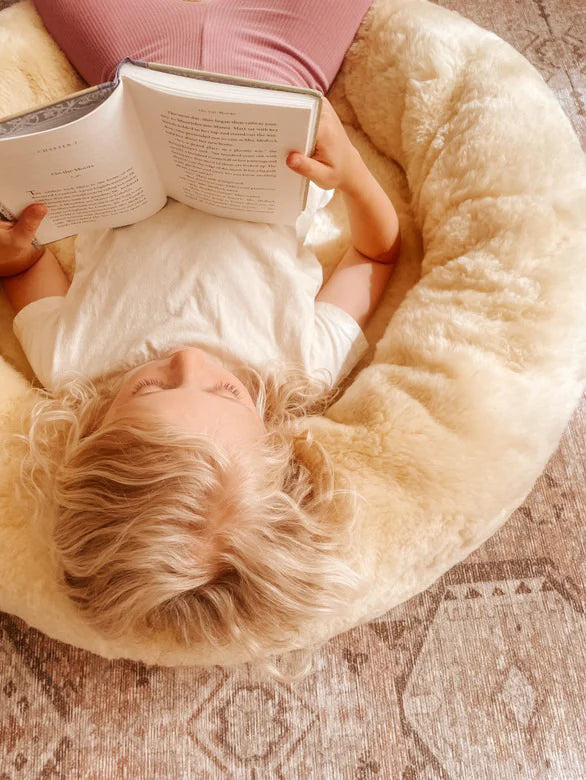 Child reading a book on the snugly