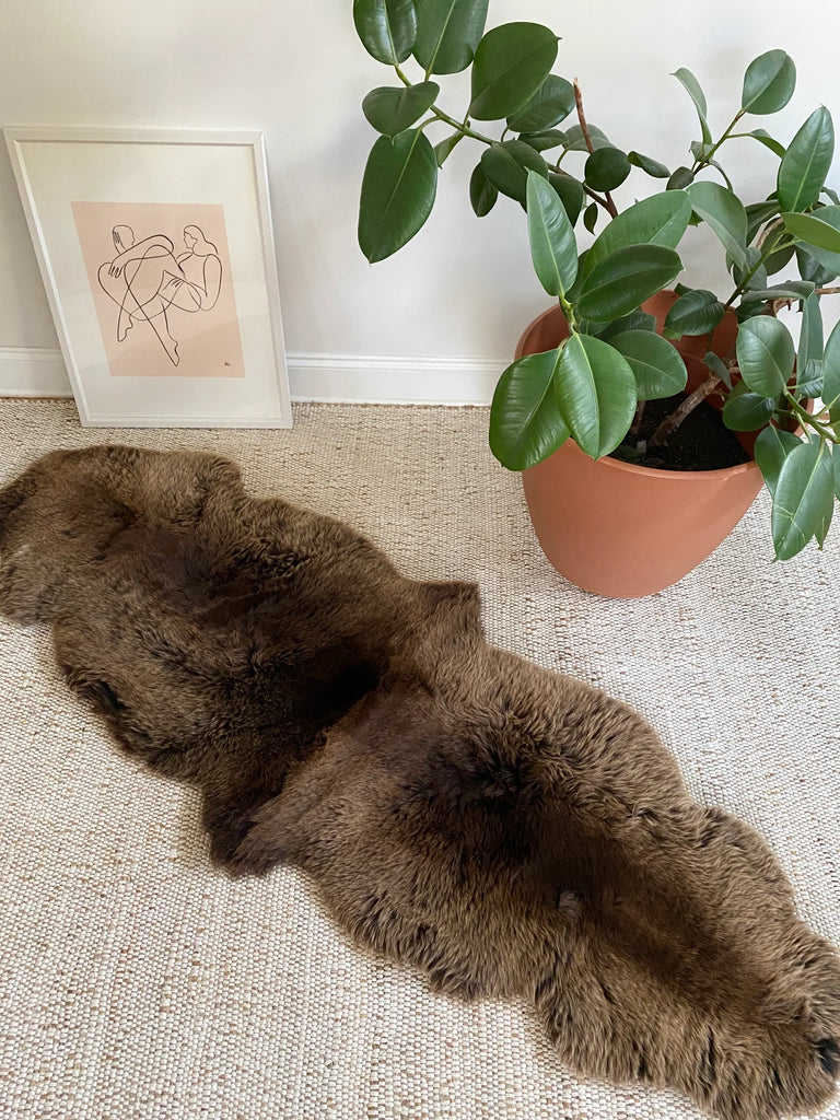 Vibrant brown double sheepskin on a beige carpet 